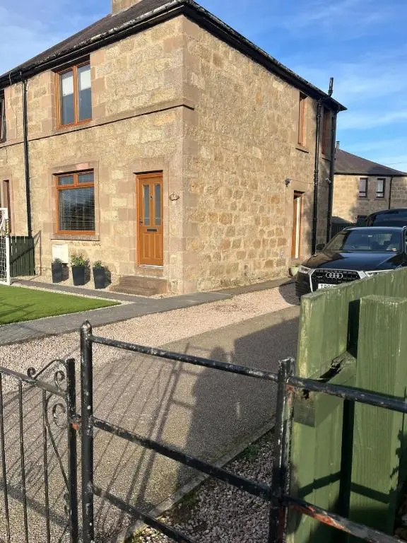 a brick house with a fence in front of it at Charlies in Huntly