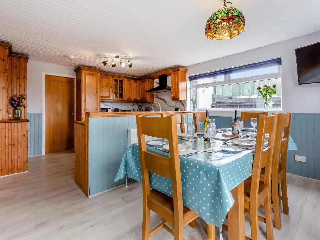 a kitchen and dining room with a table and chairs at Hogholm Farmhouse in Inverurie