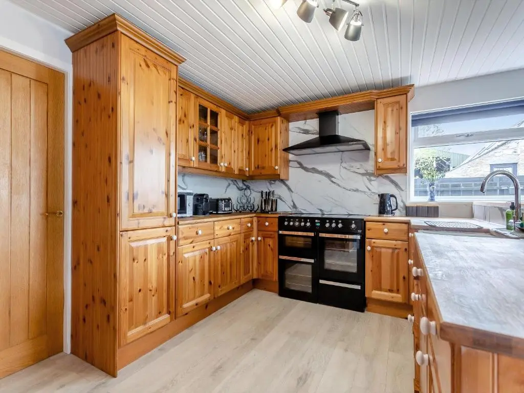 a kitchen with wooden cabinets and a stove top oven at Hogholm Farmhouse in Inverurie