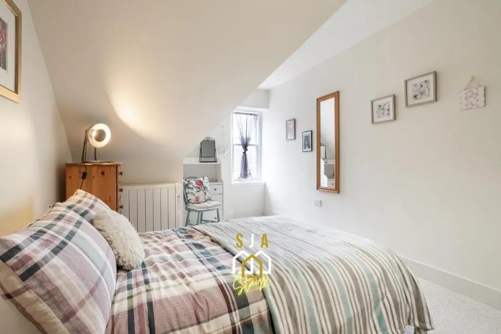 a bedroom with a bed with a blanket on it at Ballater Retreat - SJA Stays - Modern 1 Bed Apartment in Ballater