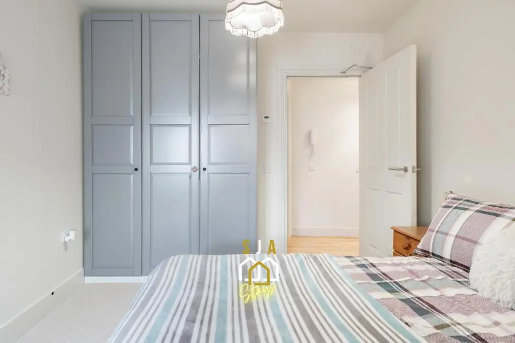 a bedroom with a bed and a closet at Ballater Retreat - SJA Stays - Modern 1 Bed Apartment in Ballater