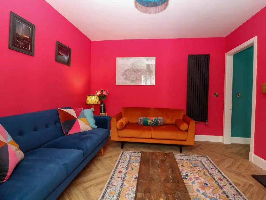 a living room with a blue couch and red walls at Evansford in Ballater