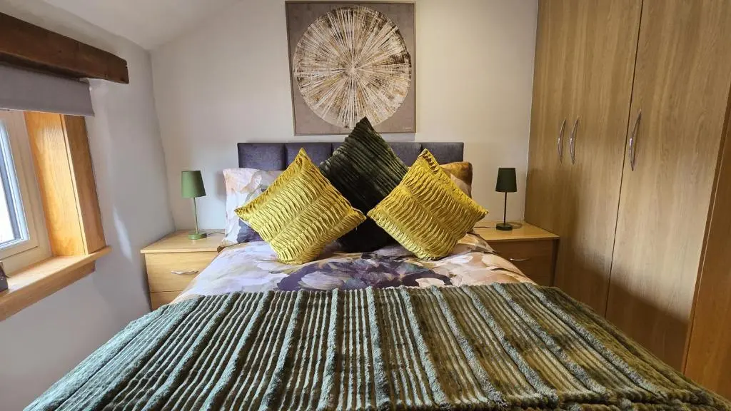 a bedroom with a large bed with yellow pillows at Stylish 1-Bed City Centre Flat in Inverness