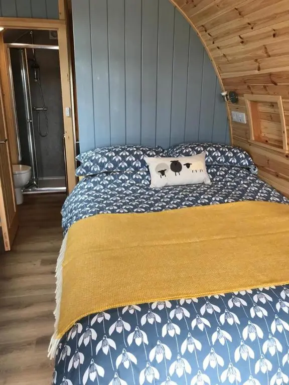 a bedroom with a bed with a cow pillow on it at Luxury Pod 3 in Bonar Bridge