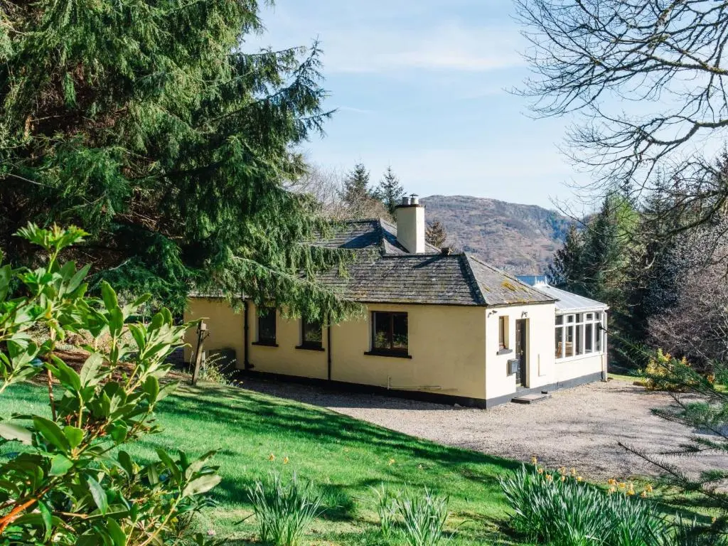 a small yellow house with a large yard at Holiday Home Farmburn Bothy by Interhome in Invermoriston