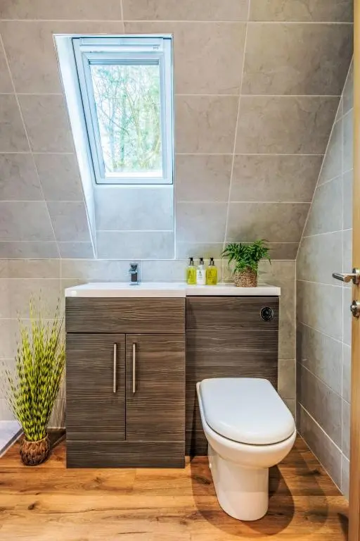 a bathroom with a toilet and a window at Chalet Sandpiper Lodge by Interhome in Spean Bridge