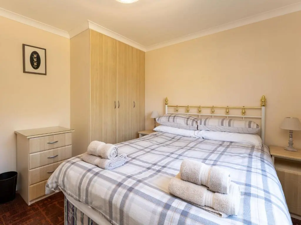 a bedroom with a bed with towels on it at Chalet Lodge 5 by Interhome in Boat of Garten