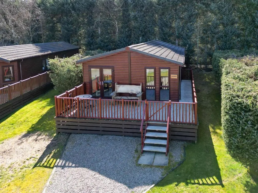 a small cabin with a staircase leading to a deck at Chalet Lodge 2 by Interhome in Boat of Garten