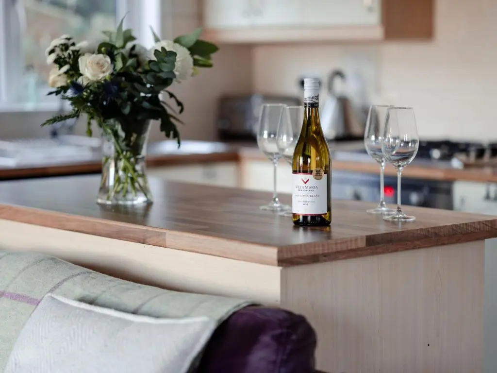 a bottle of wine sitting on a counter with two wine glasses at Chalet Lodge 2 by Interhome in Boat of Garten