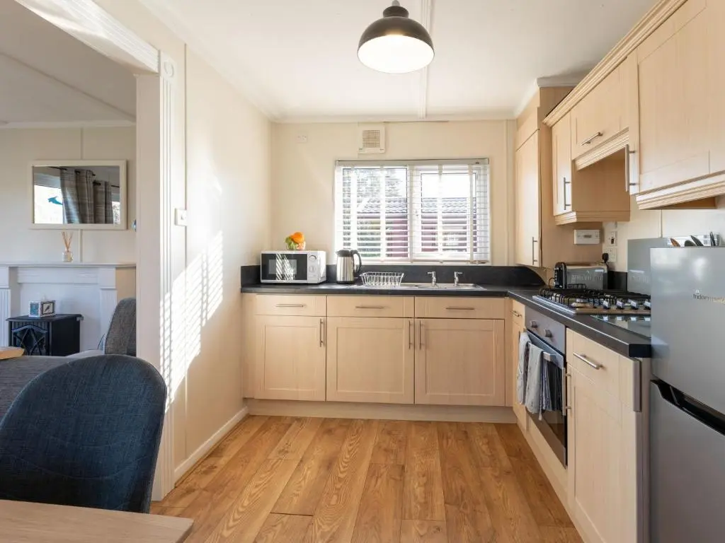 a kitchen with wooden cabinets and a counter top at Chalet Lodge 3 by Interhome in Boat of Garten