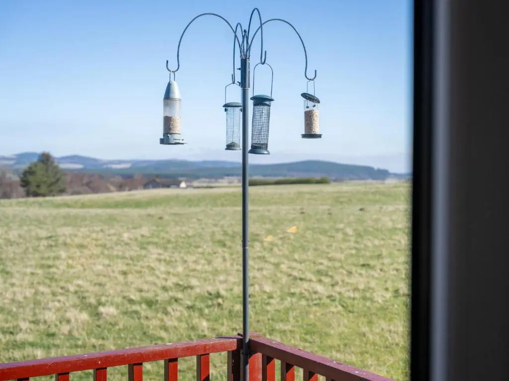 a porch with a window with a view of a field at Chalet Lodge 3 by Interhome in Boat of Garten