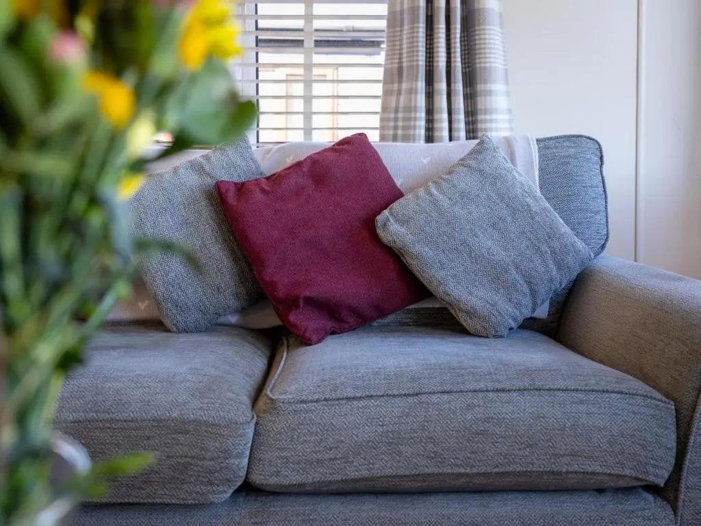 three pillows sitting on a couch in a living room at Chalet Lodge 3 by Interhome in Boat of Garten