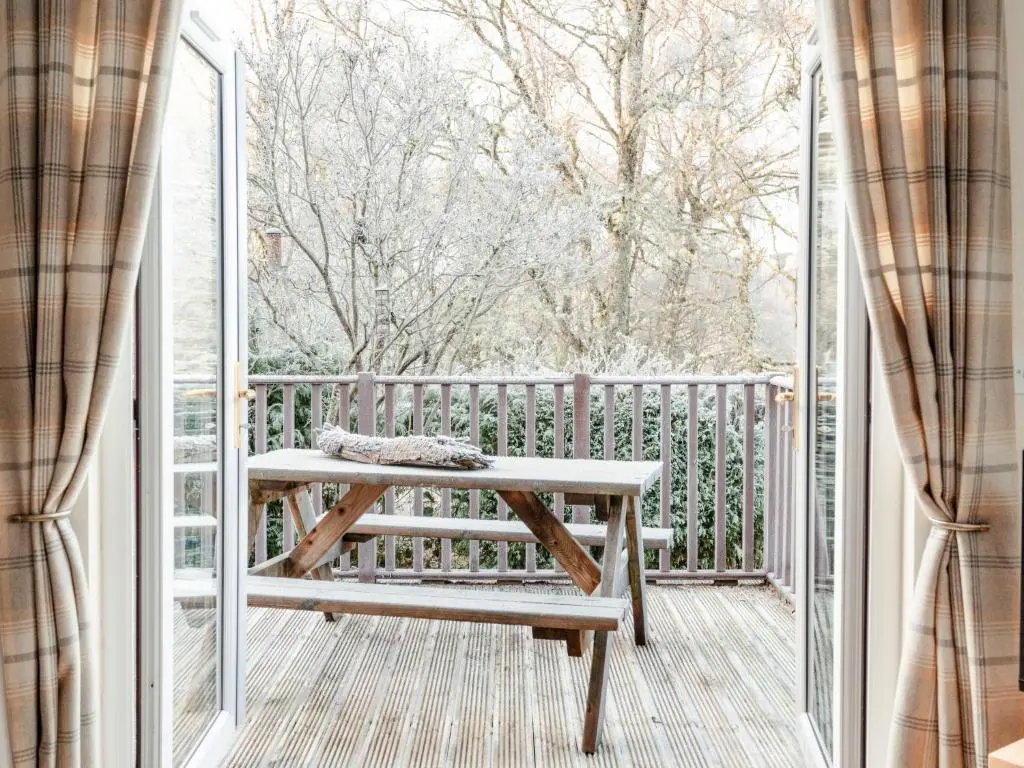 a wooden bench on a porch with a window at Chalet Lodge 4 by Interhome in Boat of Garten