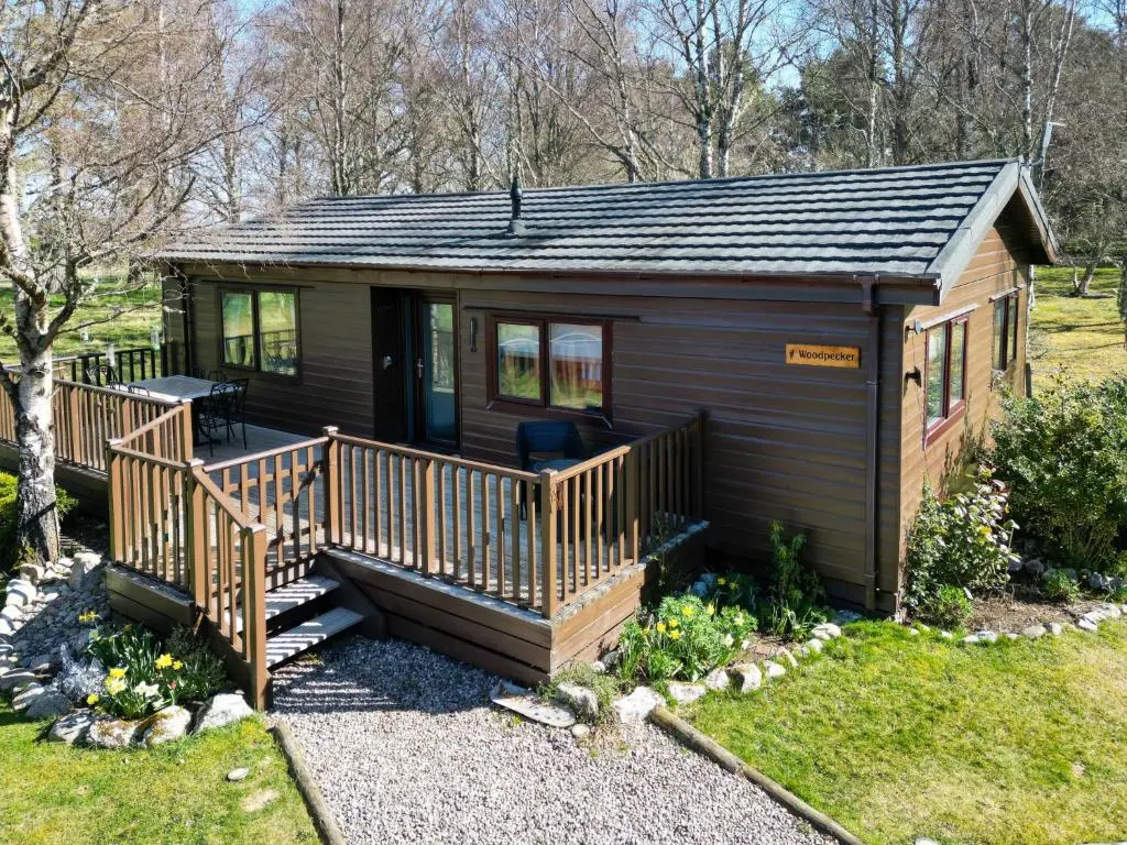 a small cabin with a porch and a deck at Chalet Lodge 8 by Interhome in Boat of Garten