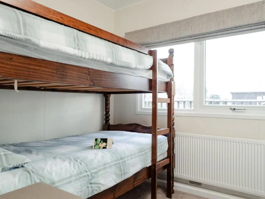 a bedroom with two bunk beds and a window at Chalet Lodge 8 by Interhome in Boat of Garten