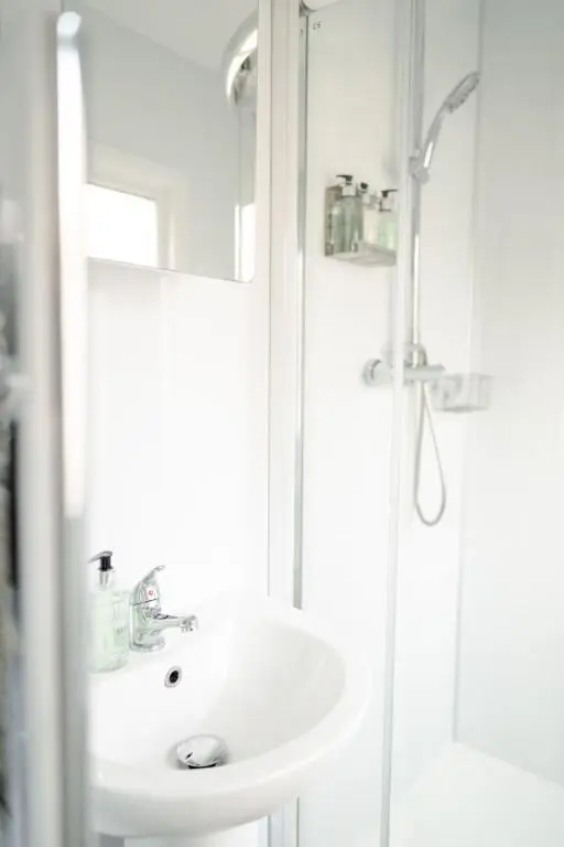 a white bathroom with a sink and a shower at Chalet Lodge 8 by Interhome in Boat of Garten
