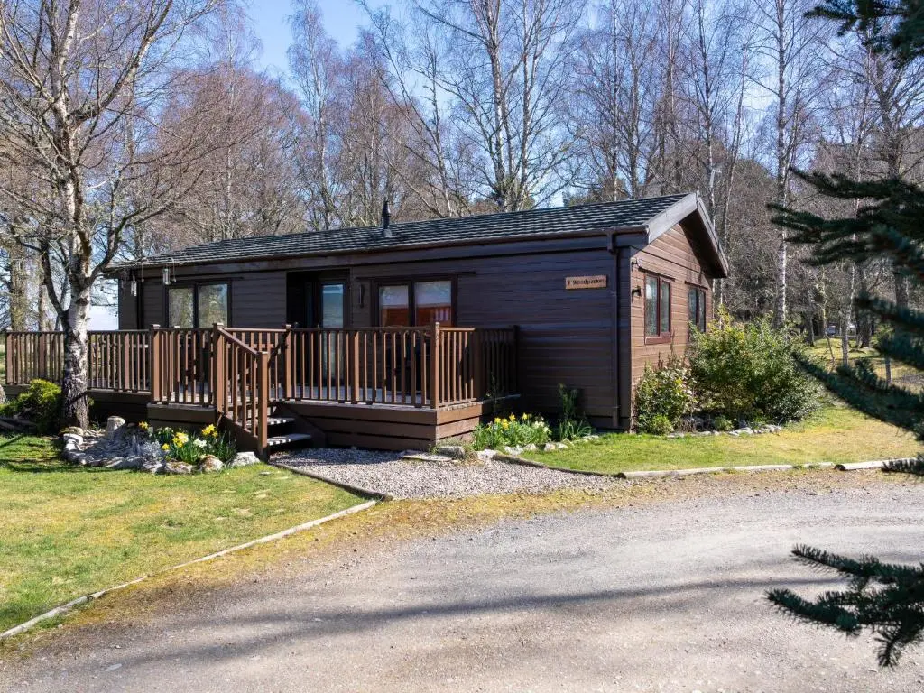 a small cabin with a porch and a deck at Chalet Lodge 8 by Interhome in Boat of Garten