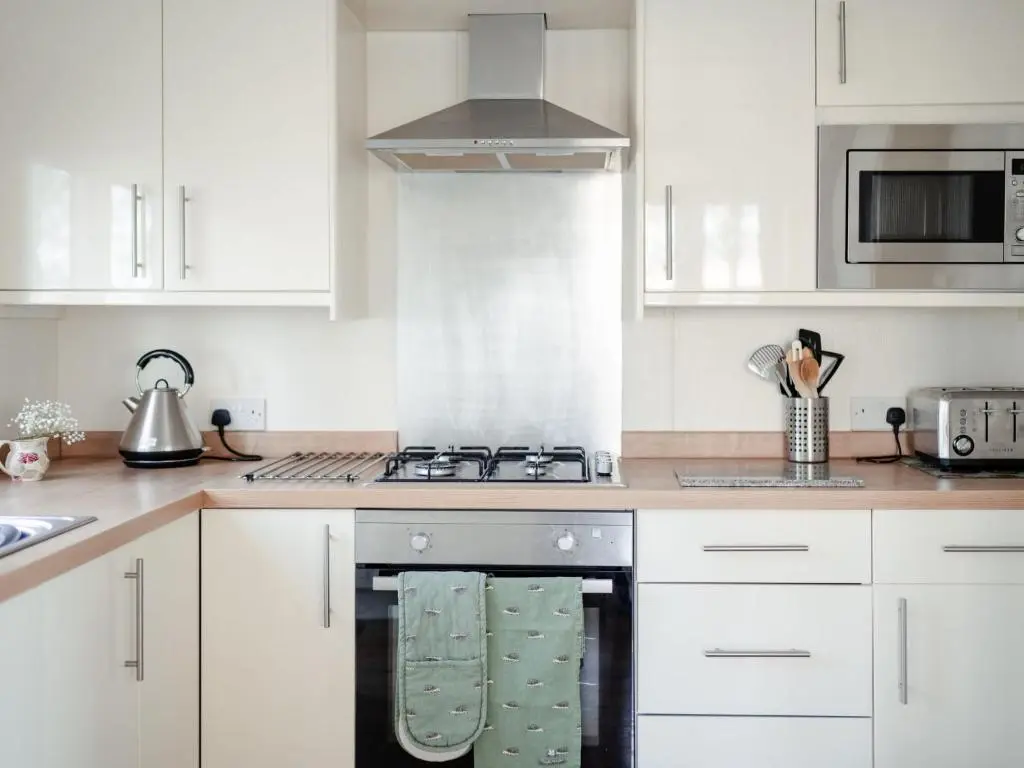 a kitchen with white cabinets and a stove top oven at Chalet Lodge 8 by Interhome in Boat of Garten