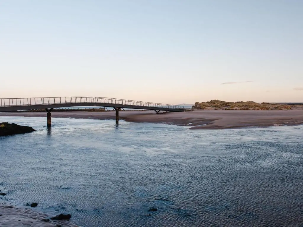 a bridge over a river next to a beach at Apartment Shore Street by Interhome in Lossiemouth