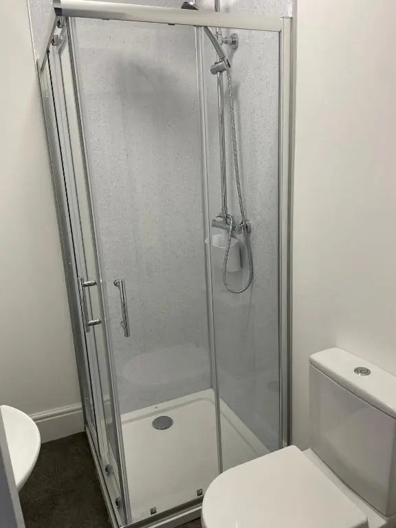 a glass shower stall in a bathroom with a toilet at Tartan House in Inverness