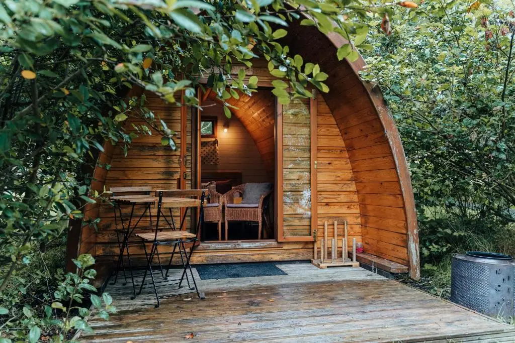 a wooden cabin with a table and chairs in it at Glenshee Glamping in Glenshee