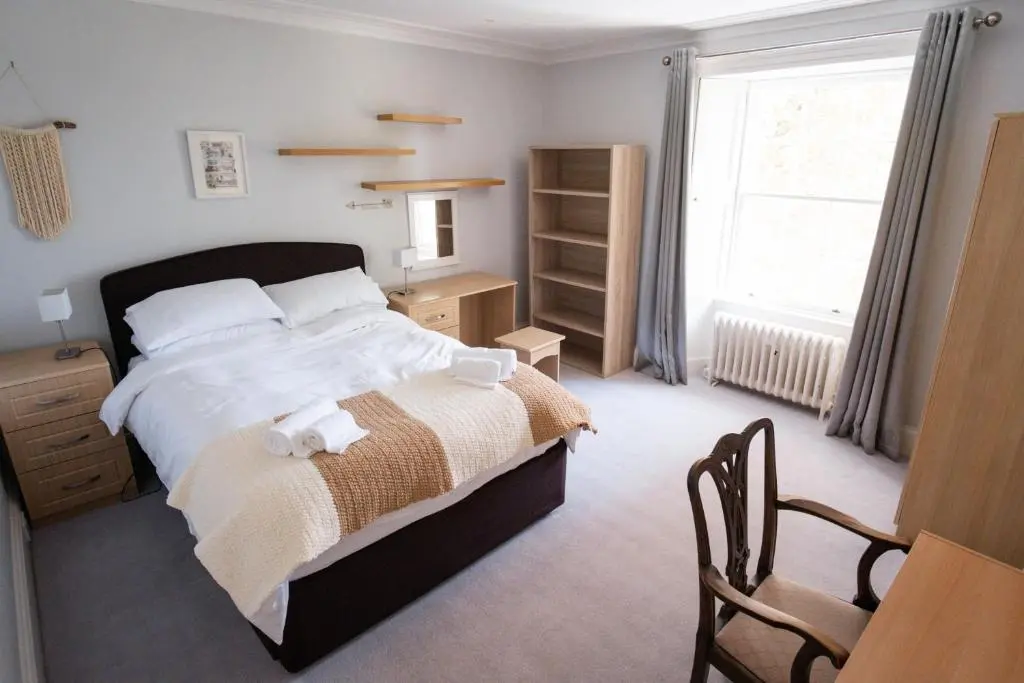 a bedroom with a bed and a desk and a window at The Old Manse Oyne in Oyne