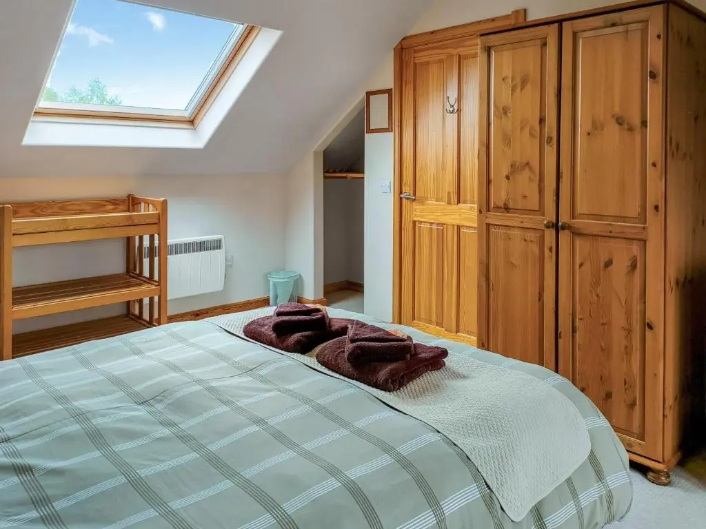 a bedroom with a bed and a skylight at Rowlands in Aviemore