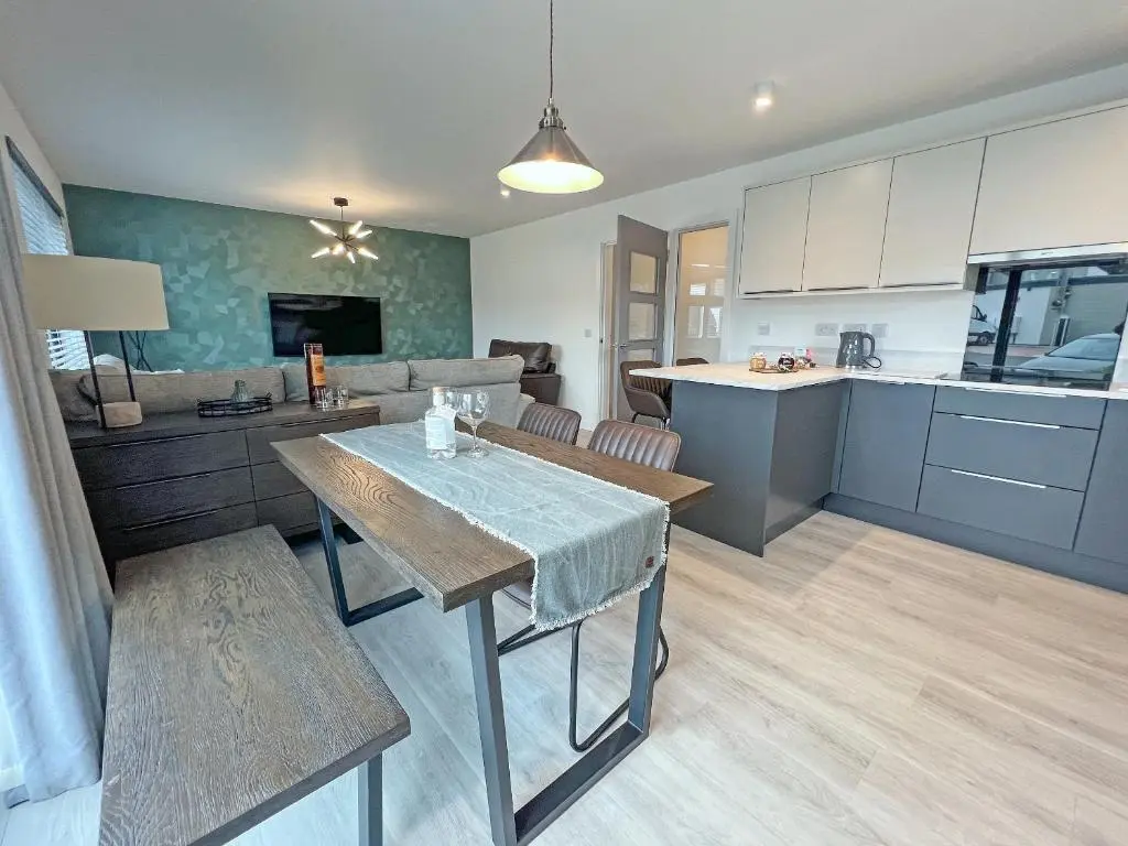 a kitchen and living room with a table and a couch at The Peaks in Aviemore