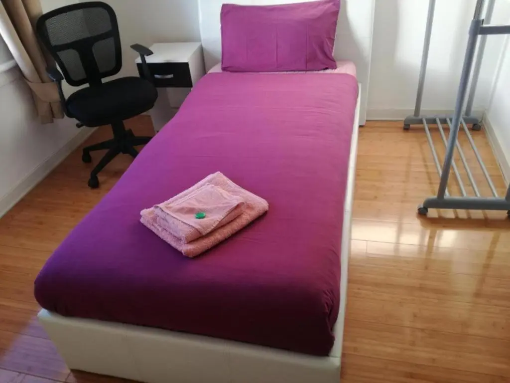 a bed with a purple blanket and a pillow on it at Ardenlea House Hotel B&b in Dyce