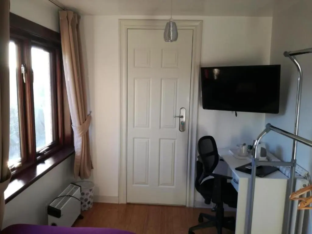 a room with a door and a chair and a desk at Ardenlea House Hotel B&b in Dyce