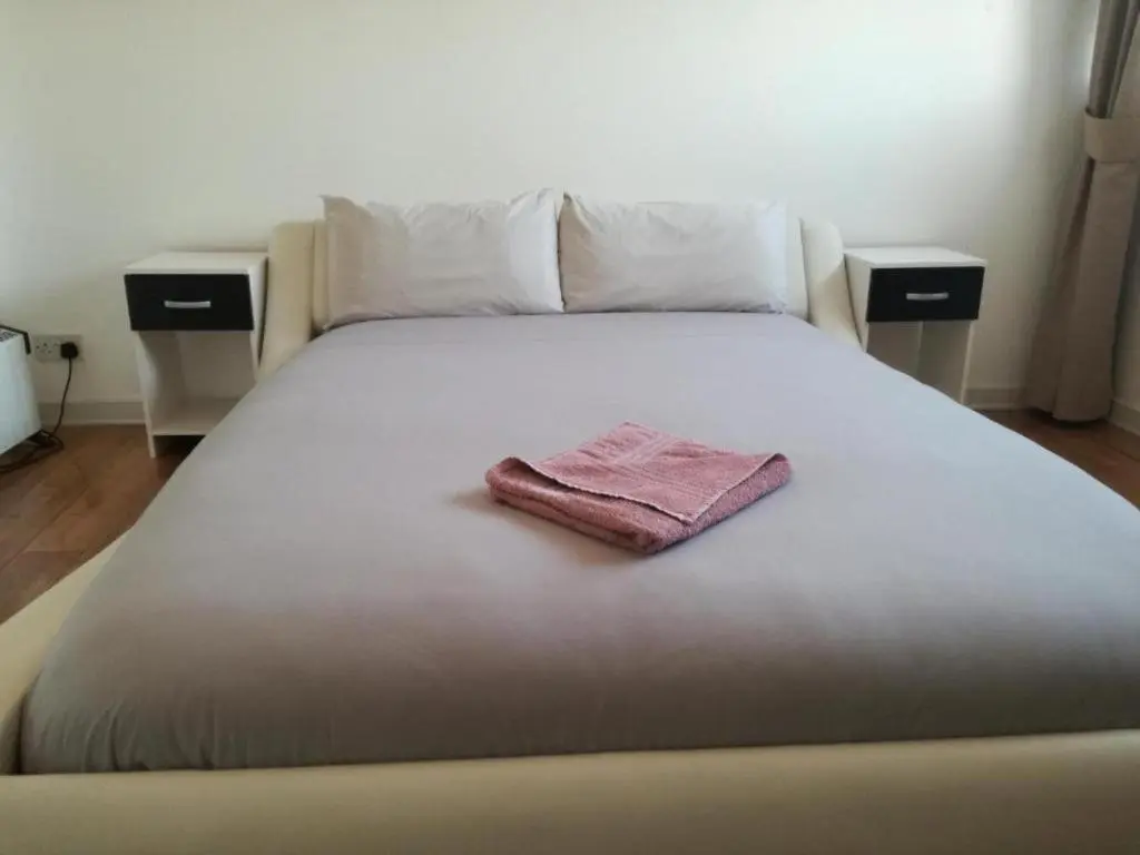 a large bed with a pink towel on it at Ardenlea House Hotel B&b in Dyce