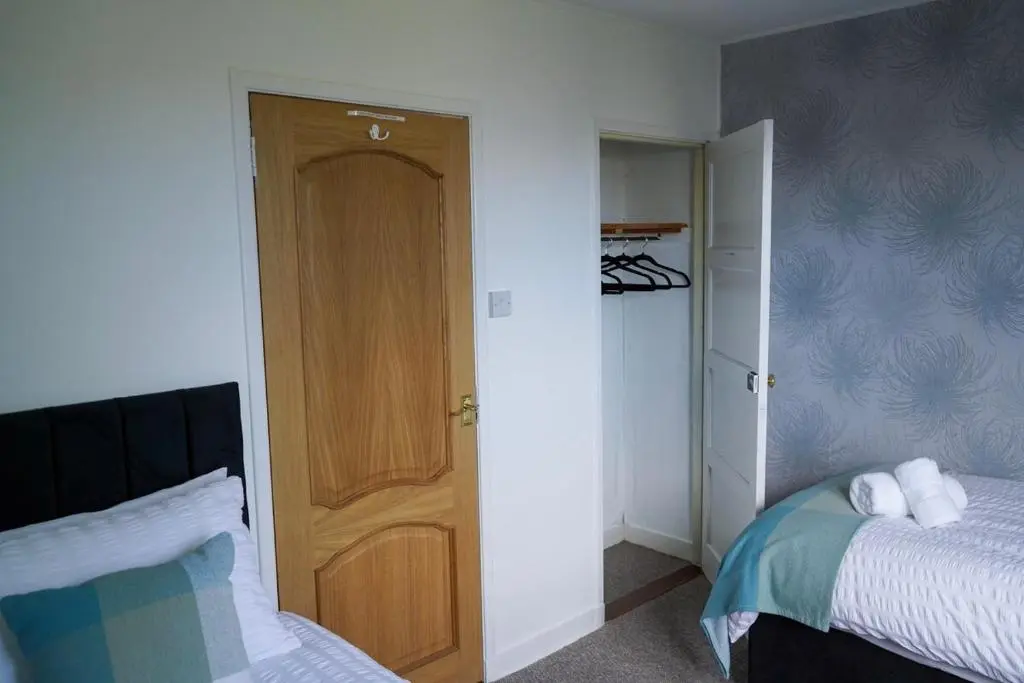 a bedroom with a bed and a wooden door at Rosehearty house - 3 bedroom in Rosehearty