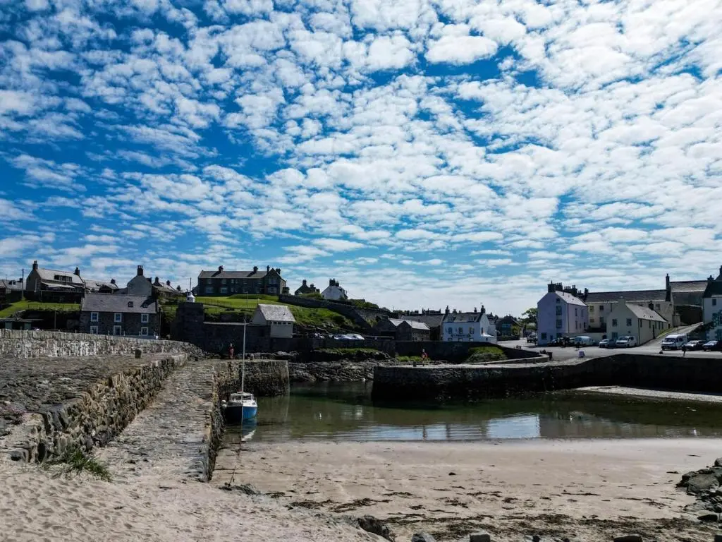 a beach with a boat in a body of water at Park House - 3 bedroom in Portsoy