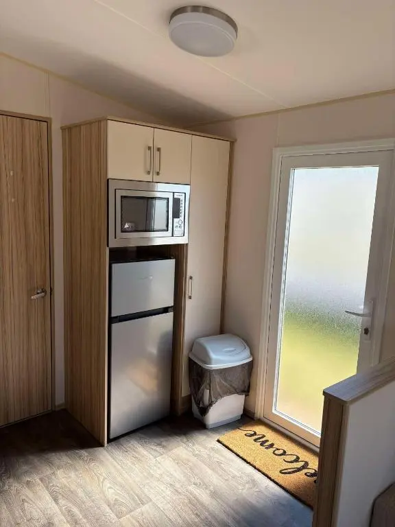 a small kitchen with a microwave and a window at Biggerstaffs retreat in Lossiemouth
