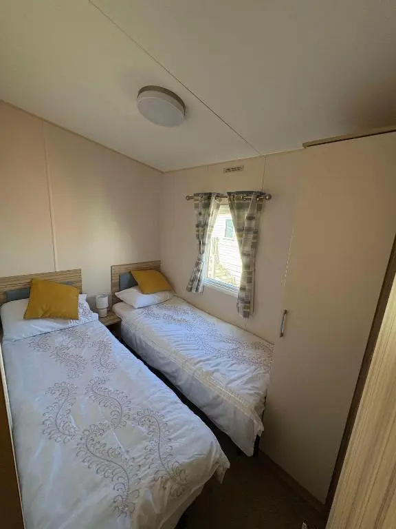 two beds in a small room with a window at Biggerstaffs retreat in Lossiemouth