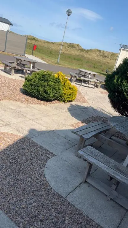 a picnic table and benches in a park at Biggerstaffs retreat in Lossiemouth