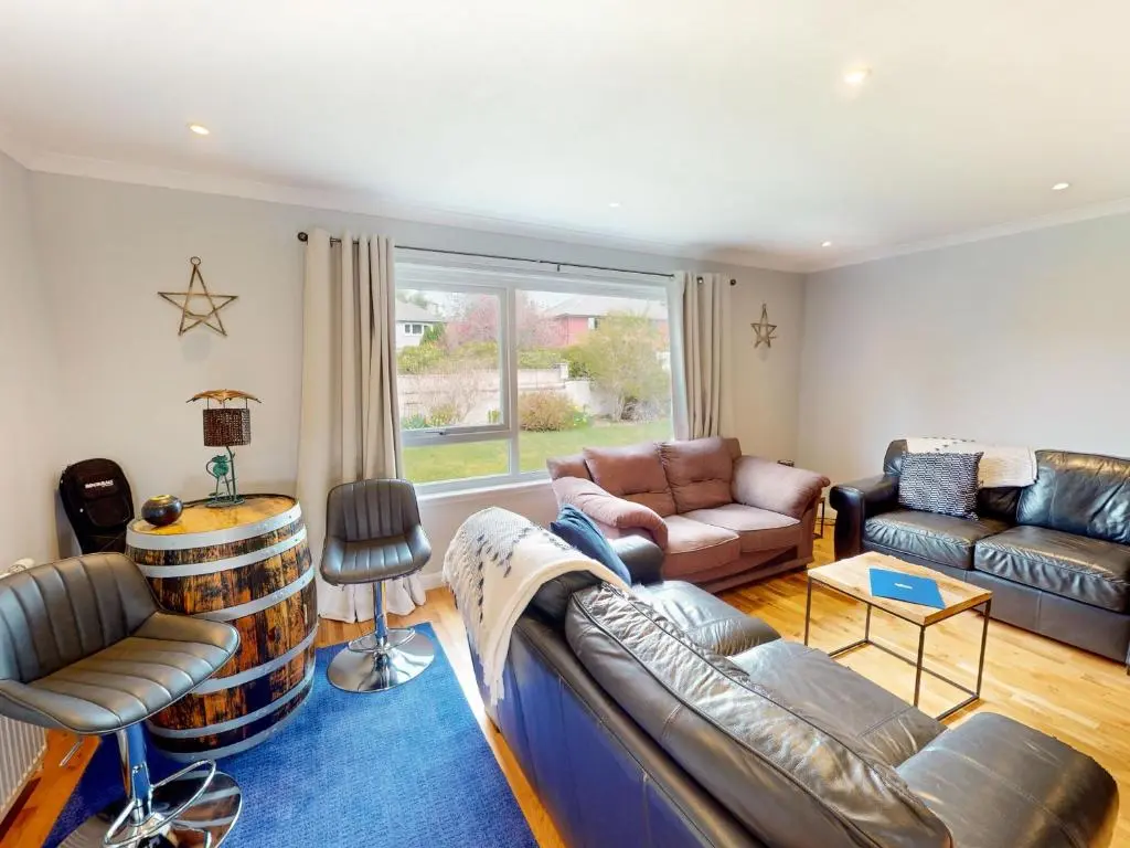 a living room with a couch and a table at Killiechangie House in Newtonmore