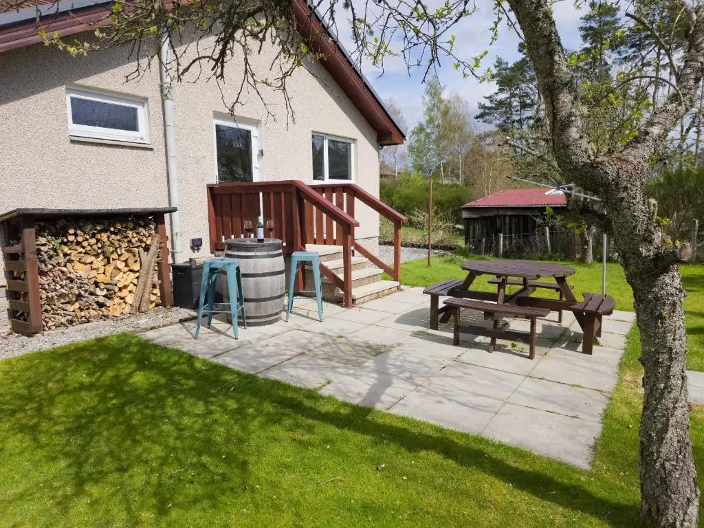 a patio with a picnic table and a grill at Killiechangie House in Newtonmore