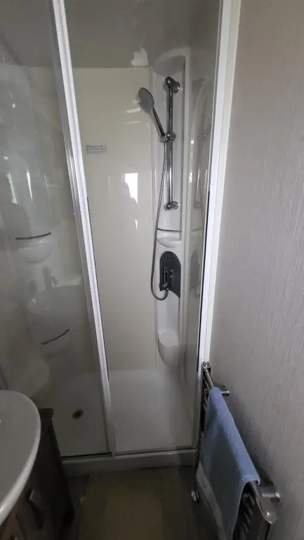 a bathroom with a shower and a sink at Northern Light Villa, forest, beach and bubbles in Burghead