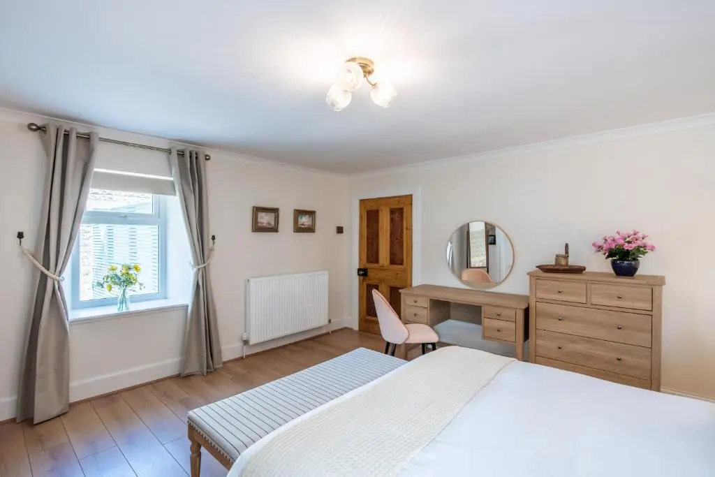 a bedroom with a bed and a desk and a window at Keel Cottage & Dog Friendly in Nairn