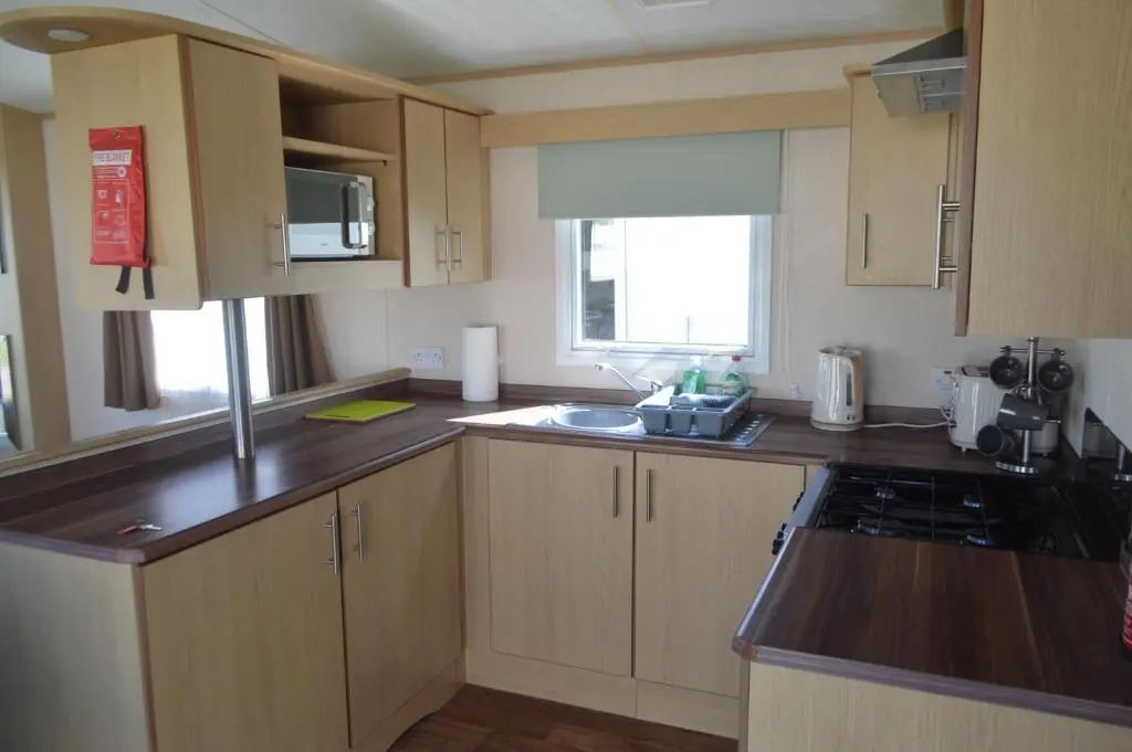 a kitchen with wooden cabinets and a counter top at C5, The Old Mill Caravan Park, Brodie in Dyke