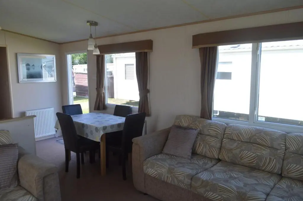 a living room with a couch and a table at C5, The Old Mill Caravan Park, Brodie in Dyke