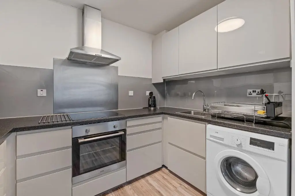 a kitchen with a sink and a washing machine at BTS 2 Bed Apart Inverness Centre in Inverness