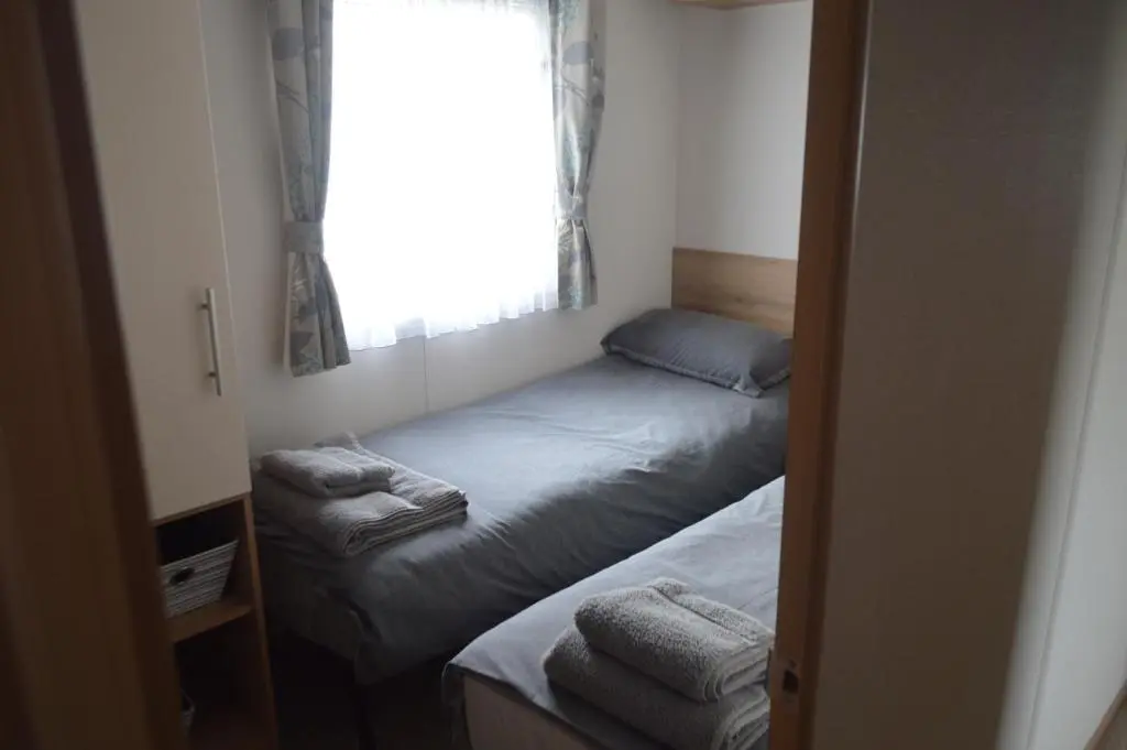 a small bedroom with two beds and a window at B5 at The Old Mill Holiday Park in Dyke