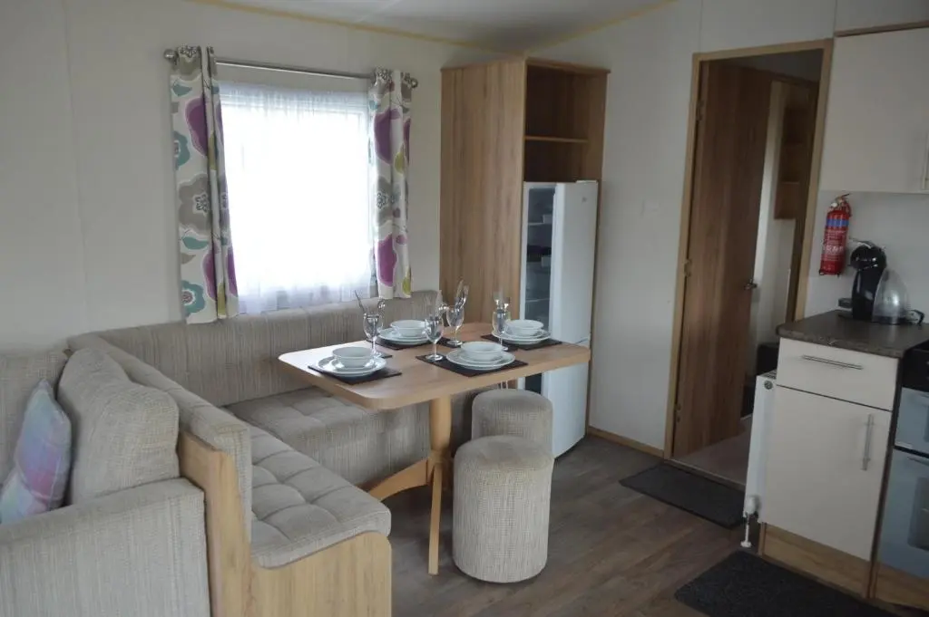 a living room with a table and a couch at B5 at The Old Mill Holiday Park in Dyke