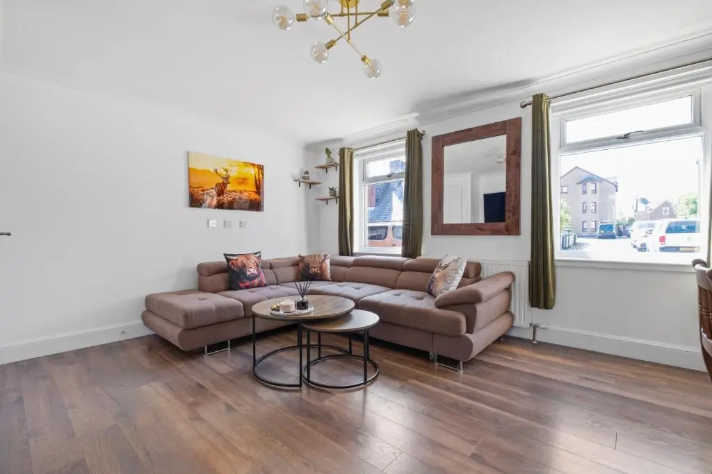 a living room with a couch and a table at Inverness Riverside Apartment with Parking in Inverness