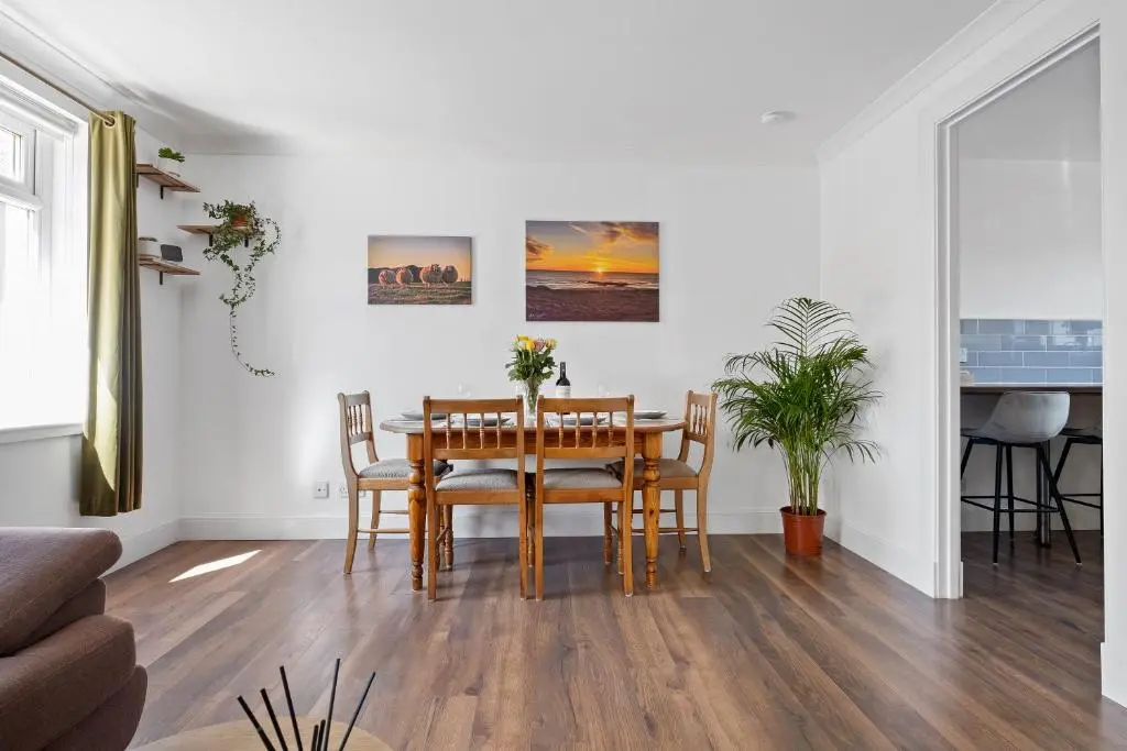 a dining room with a table and chairs at Inverness Riverside Apartment with Parking in Inverness