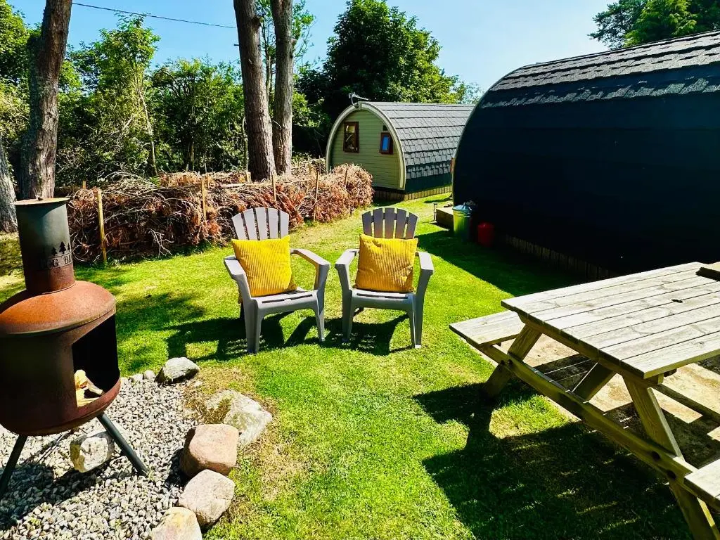 a yard with two chairs and a picnic table and a grill at Brora Escapes in Brora