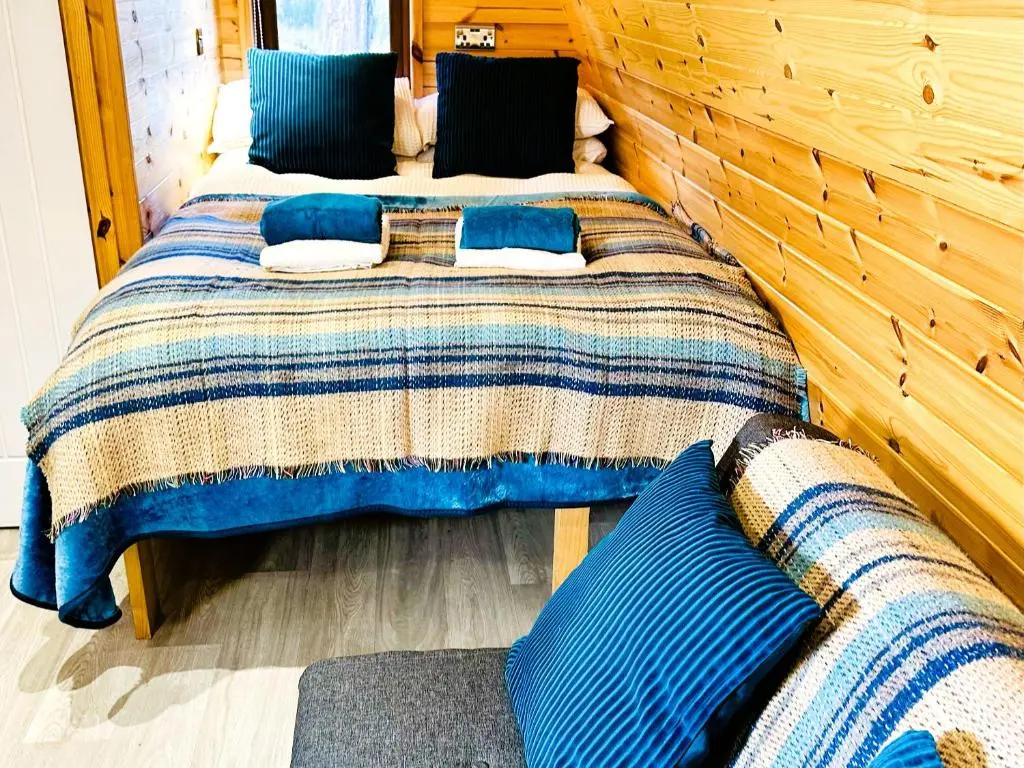 a bedroom with two beds with blue pillows at Brora Escapes in Brora