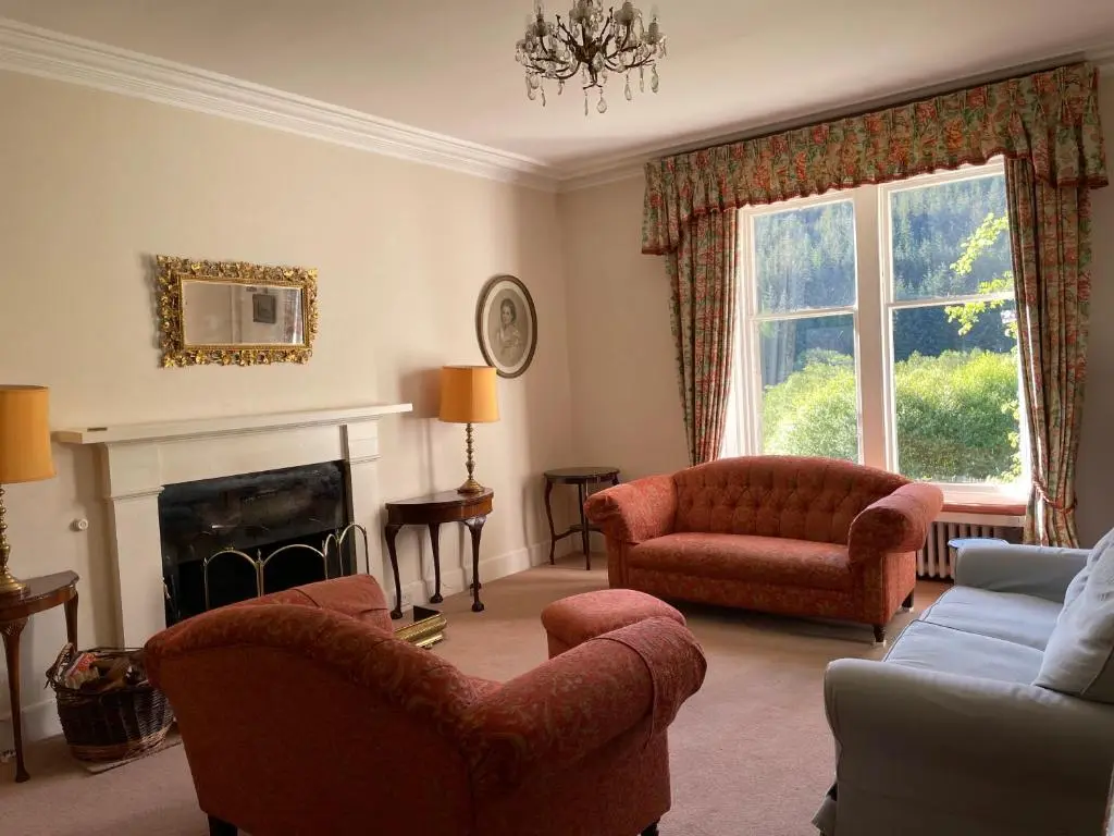 a living room with a couch and chairs and a fireplace at Glentromie Estate in Ruthven